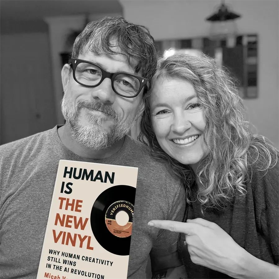Two people holding a copy of Human Is the New Vinyl